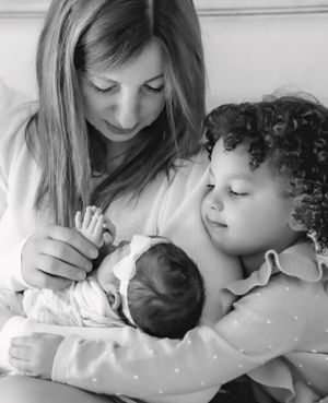 A tender moment showing a family welcoming a newborn baby in black and white.