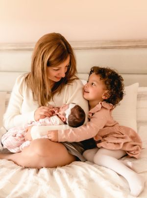 A loving family moment shared with a newborn baby on a cozy bed.