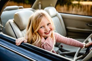 Candid moment of joy captured inside a vintage convertible car.