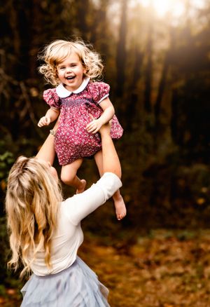 Joyful moment captured in autumn forest with expressive laughter and movement.