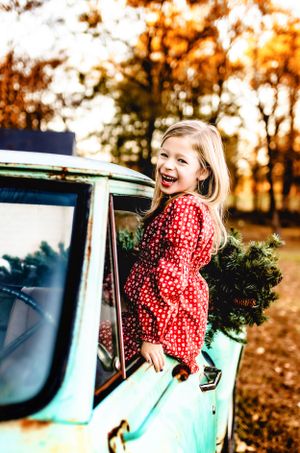 A joyful moment captured in a vintage mint green car on an autumn day with warm golden light filtering through trees.