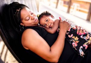 Tender moment between parent and child resting together indoors.