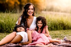 A joyful outdoor family portrait at sunset in a golden field.