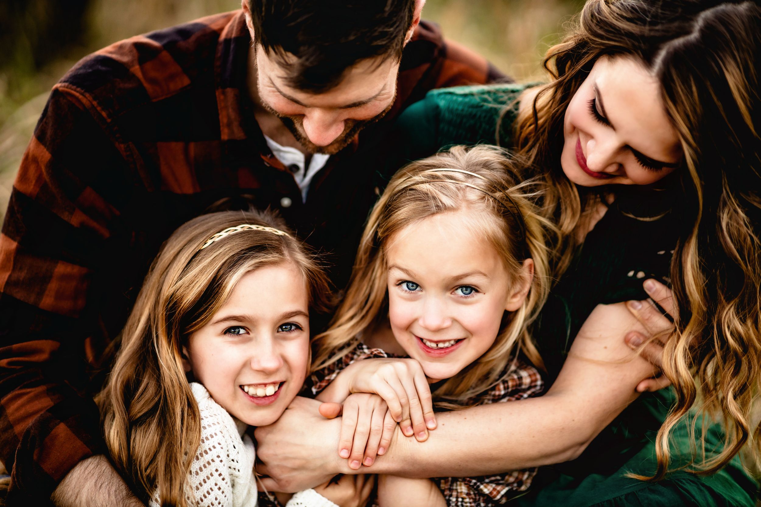 Candid family embrace captured in close-up outdoor portrait.