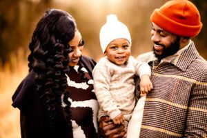 A happy family moment captured in warm golden light outdoors.