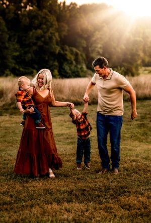 A loving family enjoying a sunset moment together in a golden field.