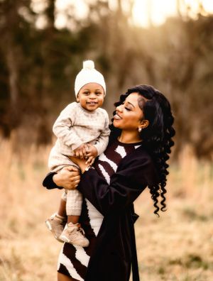 A tender moment of joy and laughter shared between parent and child against a golden sunset.