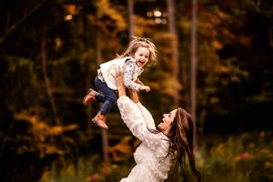 Playful moment captured in a backlit forest setting with joyful interaction.