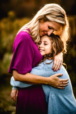 Tender embrace between parent and child in warm evening light.