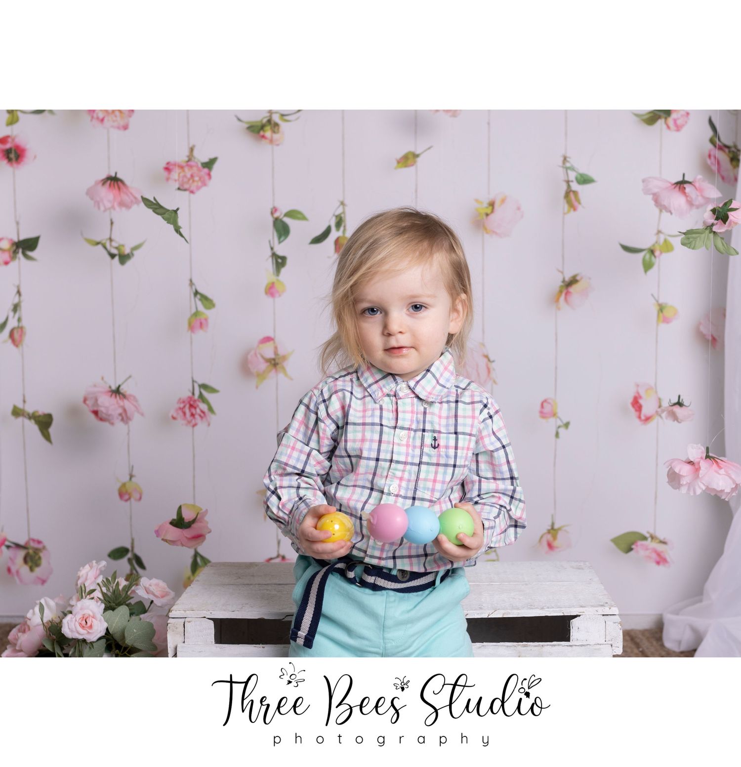 Spring portrait setup with floral backdrop and pastel colored Easter eggs.