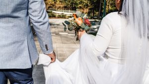 Close-up view of formal attire and a bouquet during an outdoor wedding ceremony.