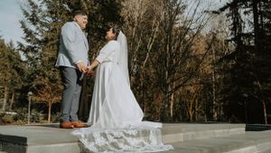 A couple shares a moment on a stone platform surrounded by bare winter trees.