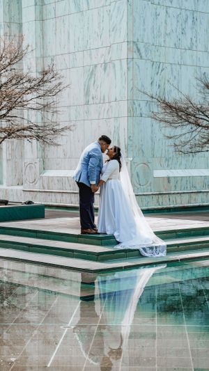 Romantic moment between newlyweds on marble steps with beautiful reflection in foreground.