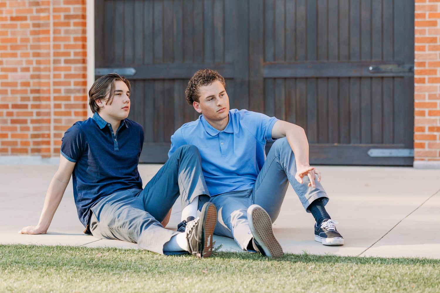 Two young brothers, dressed in blue, looking off into the distance.