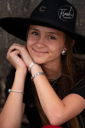 Black and white portrait series showing playful expressions and a baseball cap against dark background.