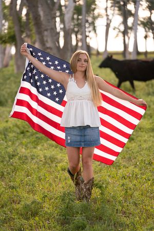 American flag photography series with cowboy boots in a grassy field at sunset.