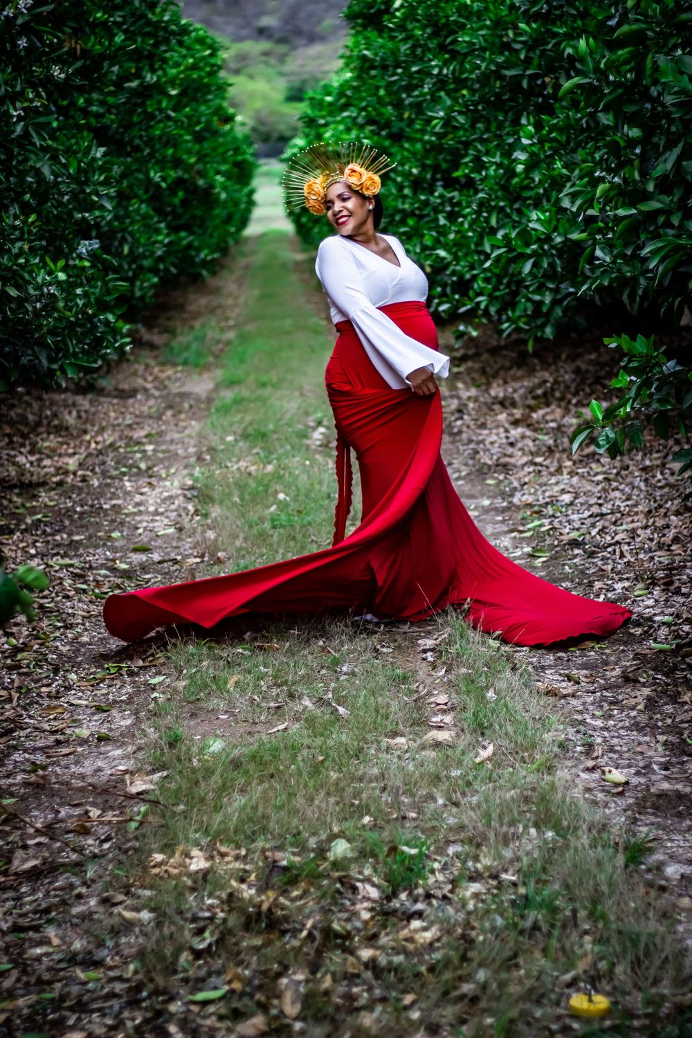 pregnant woman wearing crown maternity dress red orchard dancing expecting baby