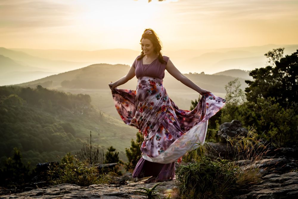 pregnant woman dancing cliff sunset photography photo shoot maternity dress valley background
