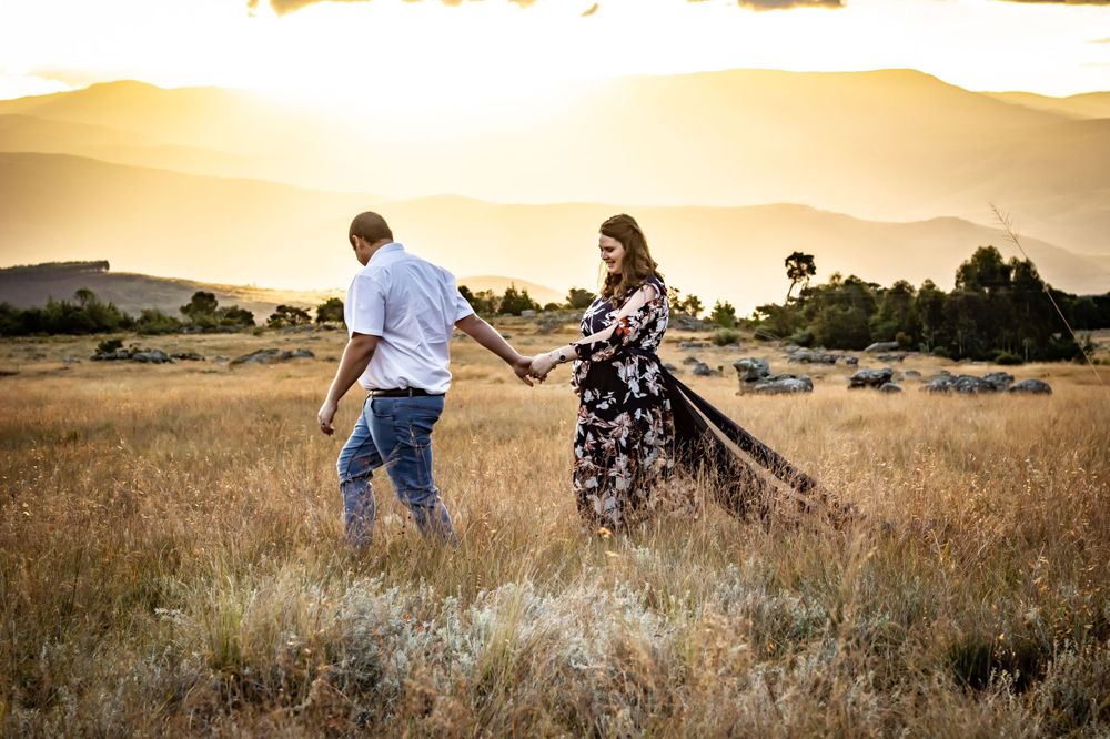 couple walking man leading woman pregnant maternity dress field sunset landscape photography photo lowveld nelspruit