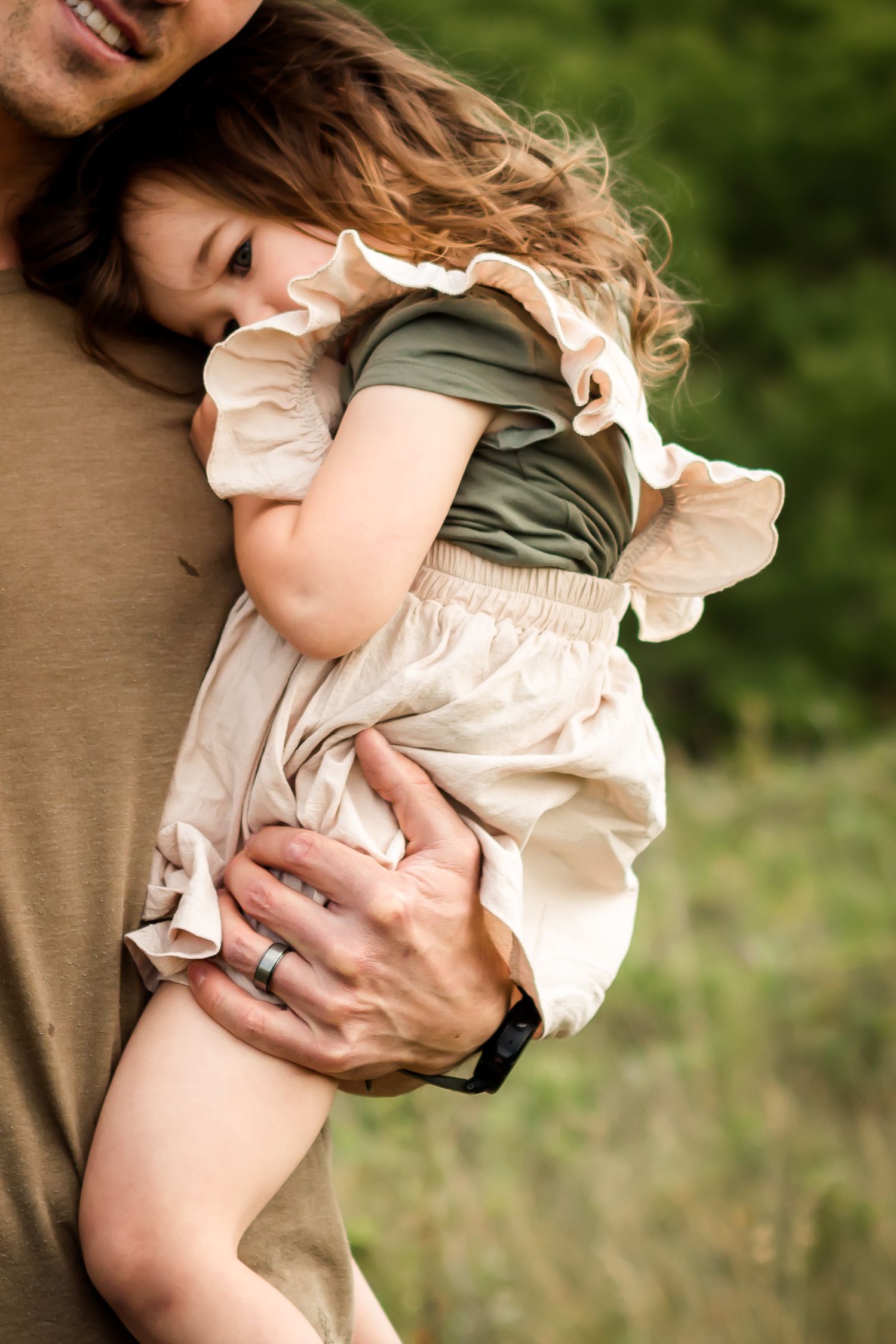 Daddy daughter moment captured at Nose Hill Park in summer for lifestyle family photography session in Calgary AB.