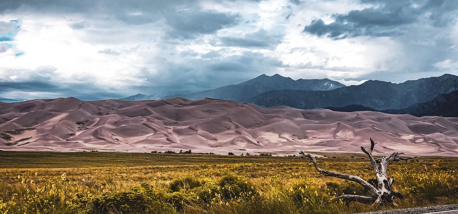 Sand dunes and mountain ranges stretch across the landscape at Great Sand Dunes National Park.