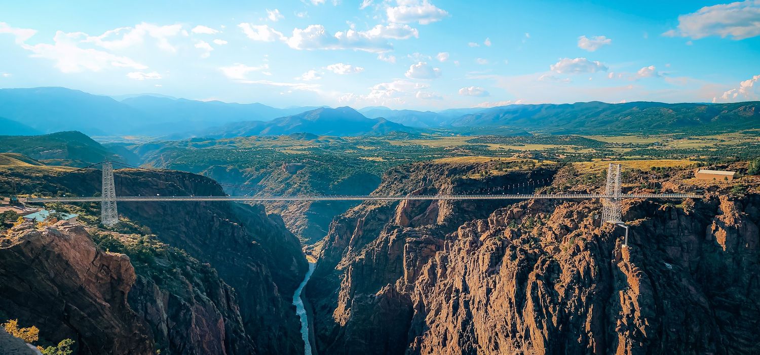 Royal Gorge Bridge spans a dramatic canyon with towering rock walls and winding river below in Colorado.