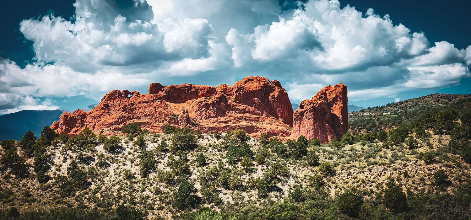 Dramatic red rock formations rise from the desert landscape at Garden of the Gods in Colorado.