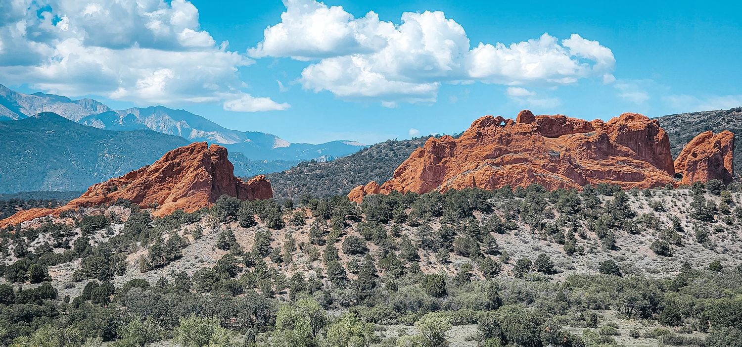 Red rock formations stand out against desert landscape at Garden of the Gods in Colorado.