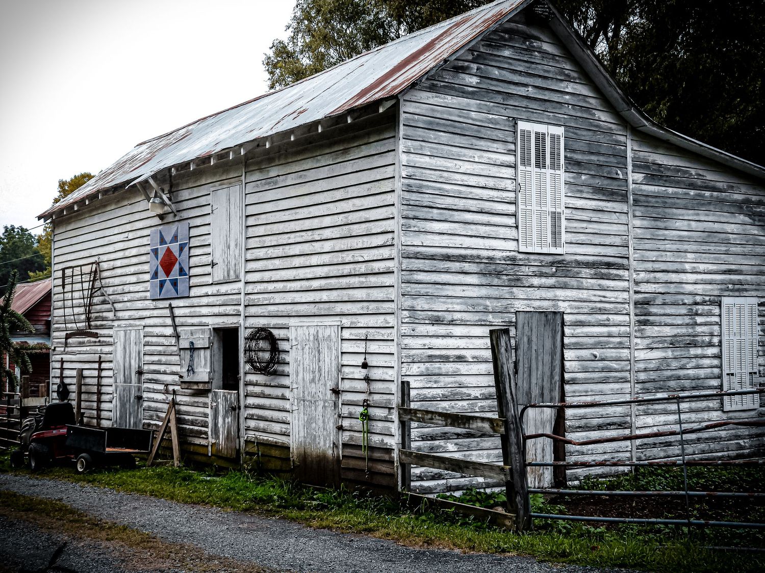Weathered white wooden barn with rustic charm displays American flag decor.