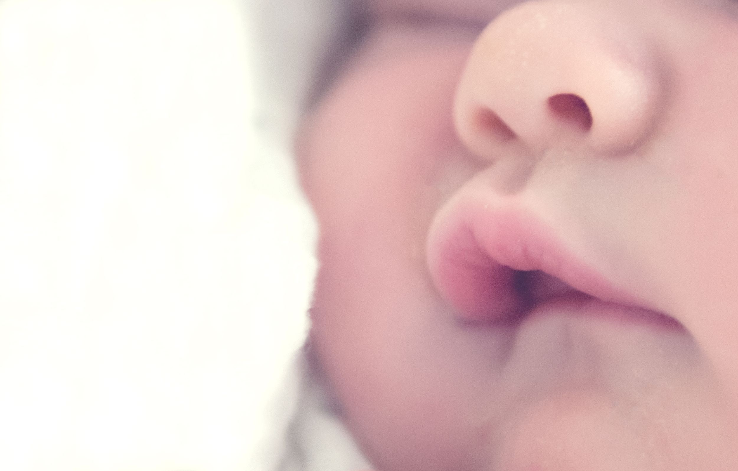 Extreme close-up photograph of a sleeping baby's peaceful face.
