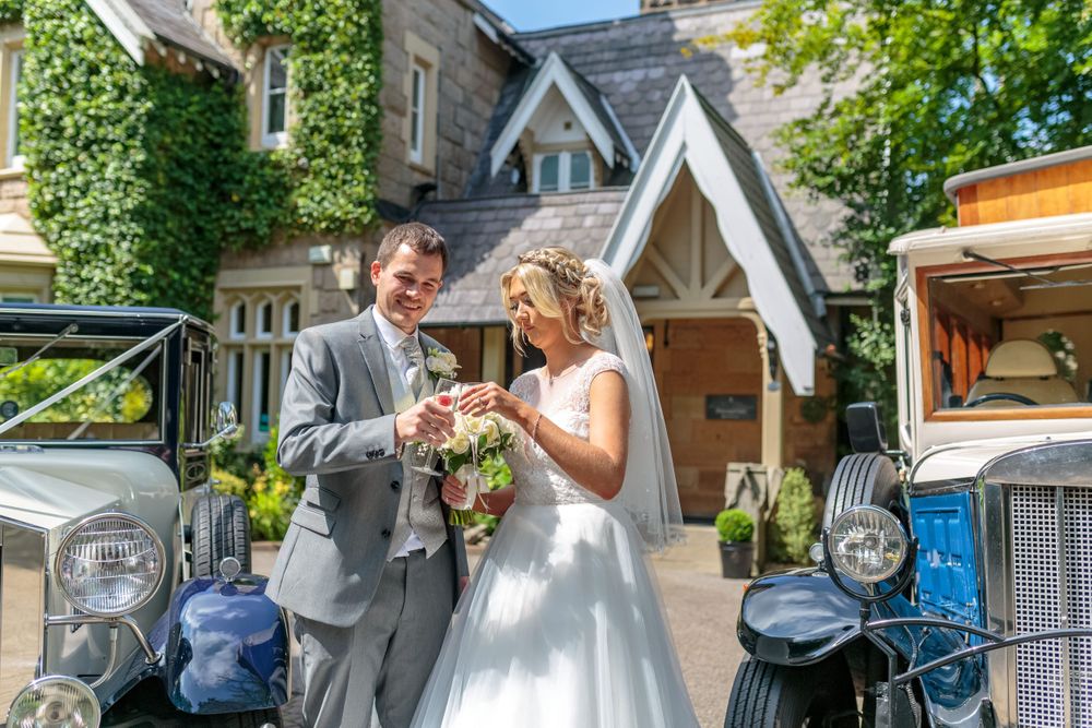 bride and groom clink champagne glasses in the sunshine
