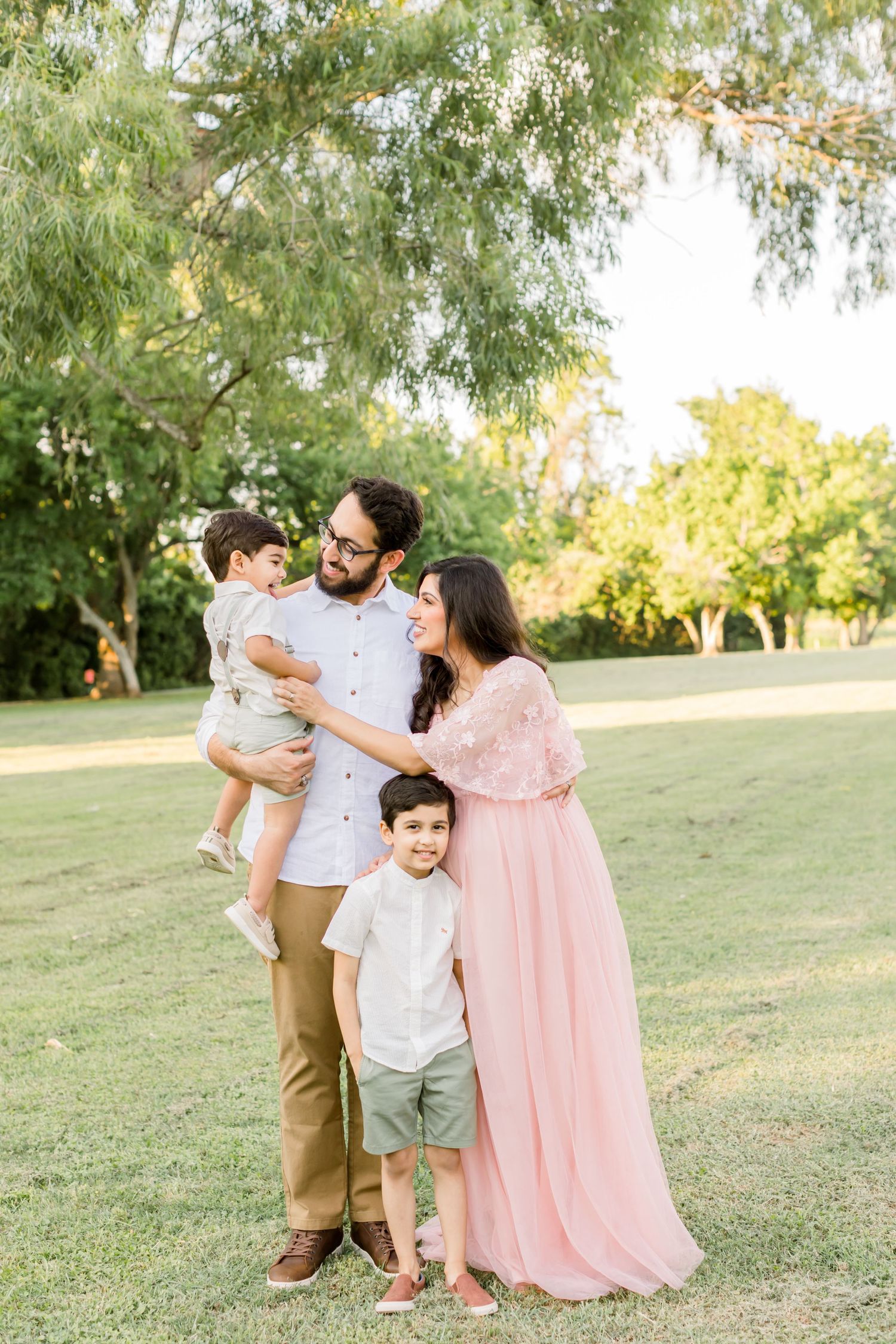 A family portrait in a park shows four people in coordinated pastel outfits.