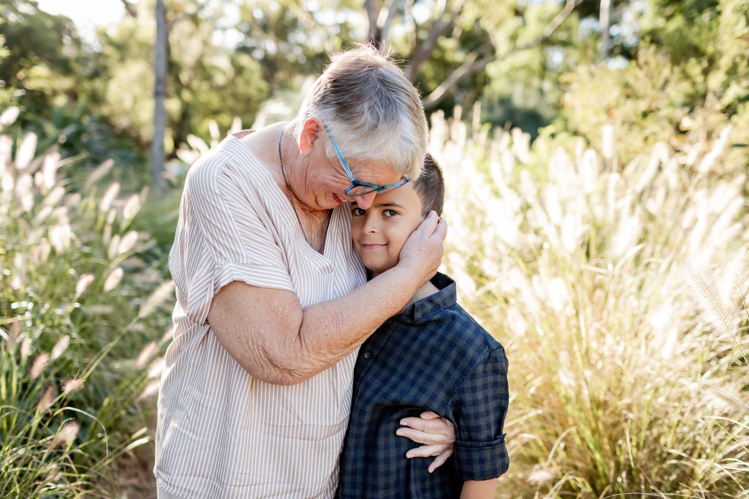 An intimate moment shared between two people on a nature trail surrounded by tall grasses.