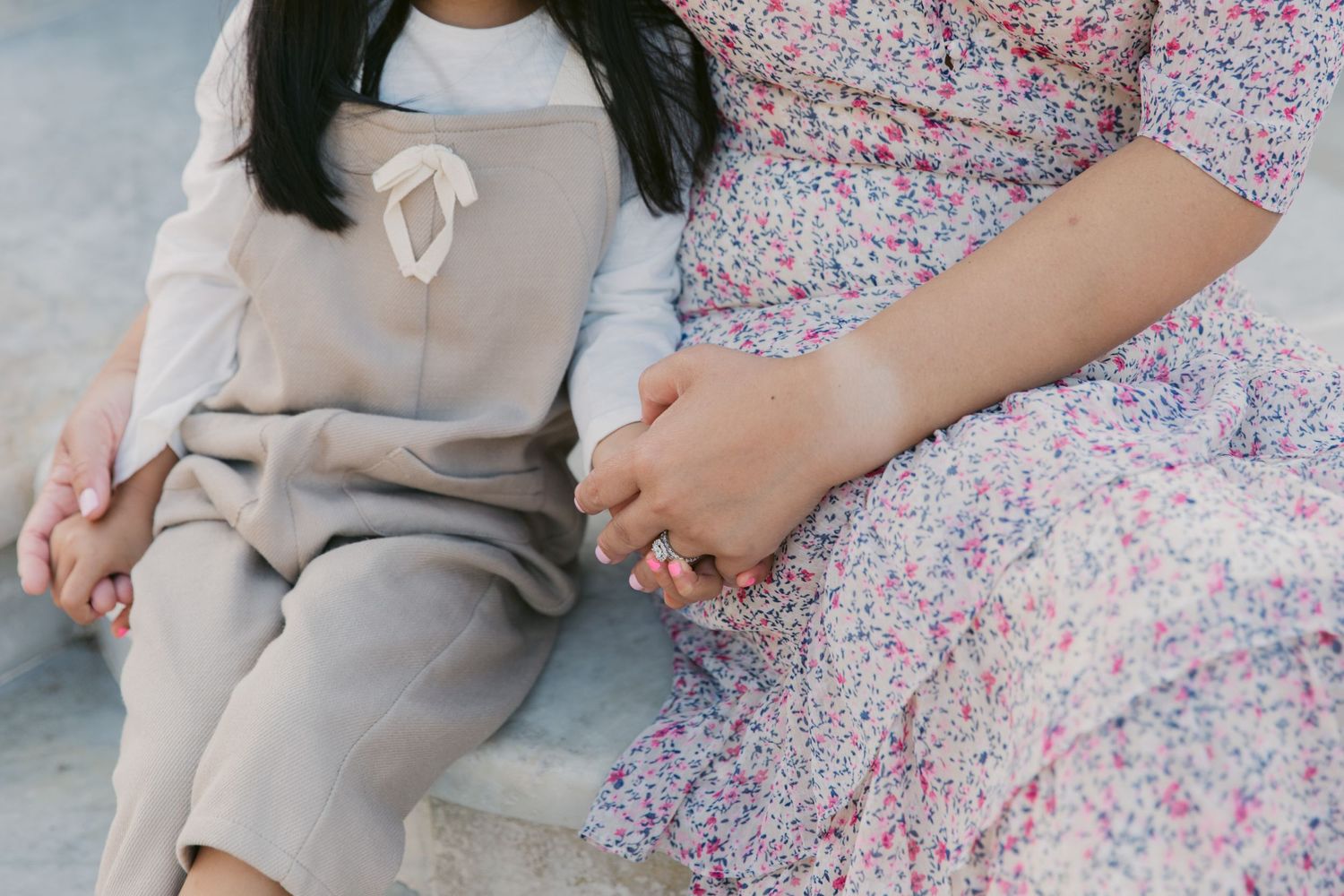 A couple shares a tender moment while sitting on ornate stone steps.