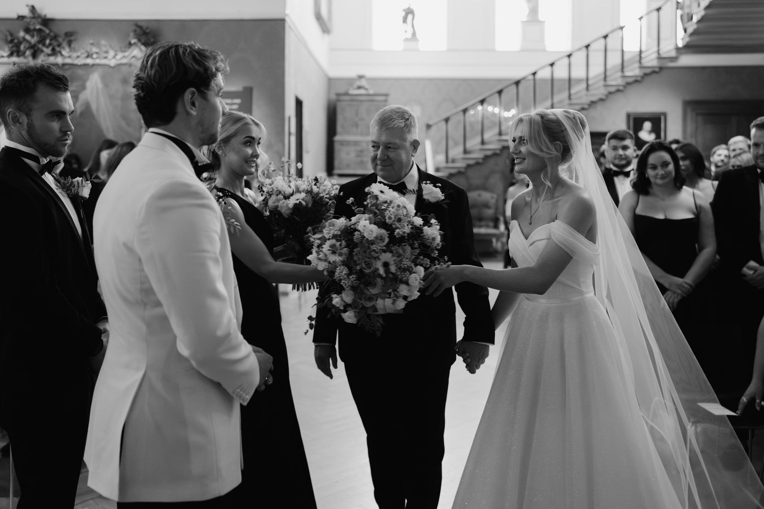 bride giving bouquet to bridesmaid at the alter in the European art gallery at the ashmolean museum
