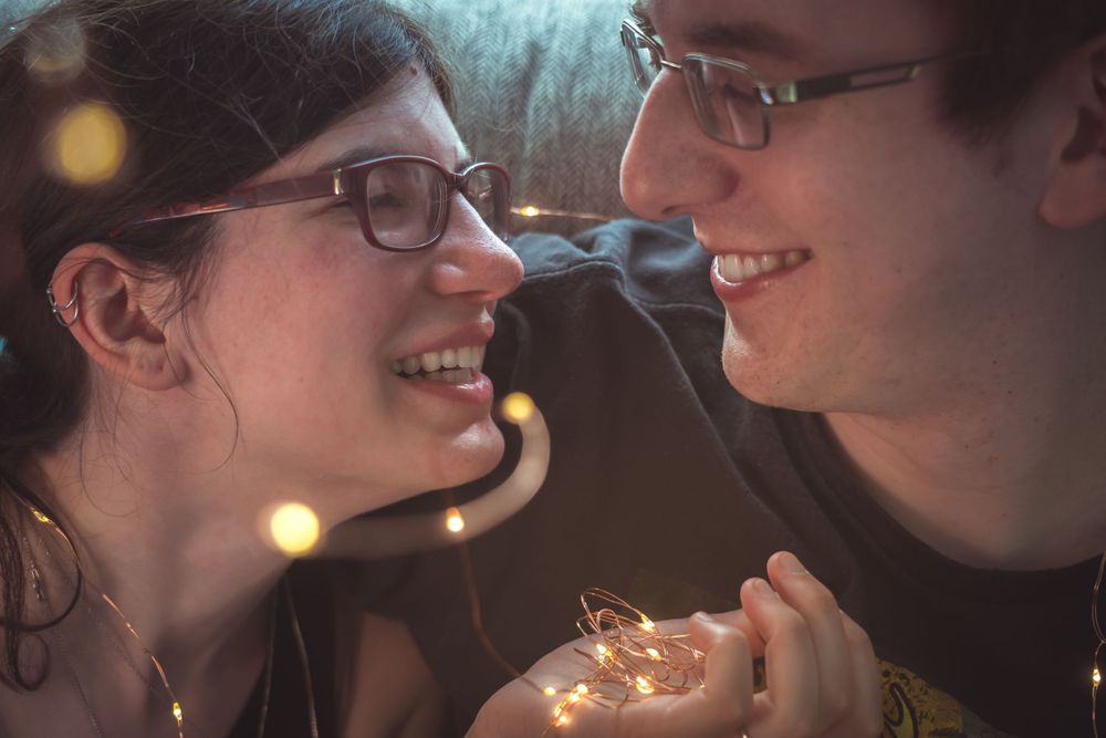 A romantic moment shared between a couple with bokeh lights in the background.