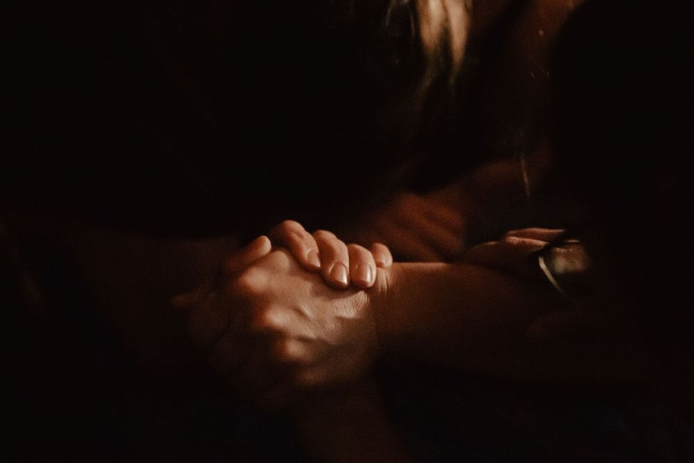 Intimate couple sharing a tender moment in dramatic lighting.
