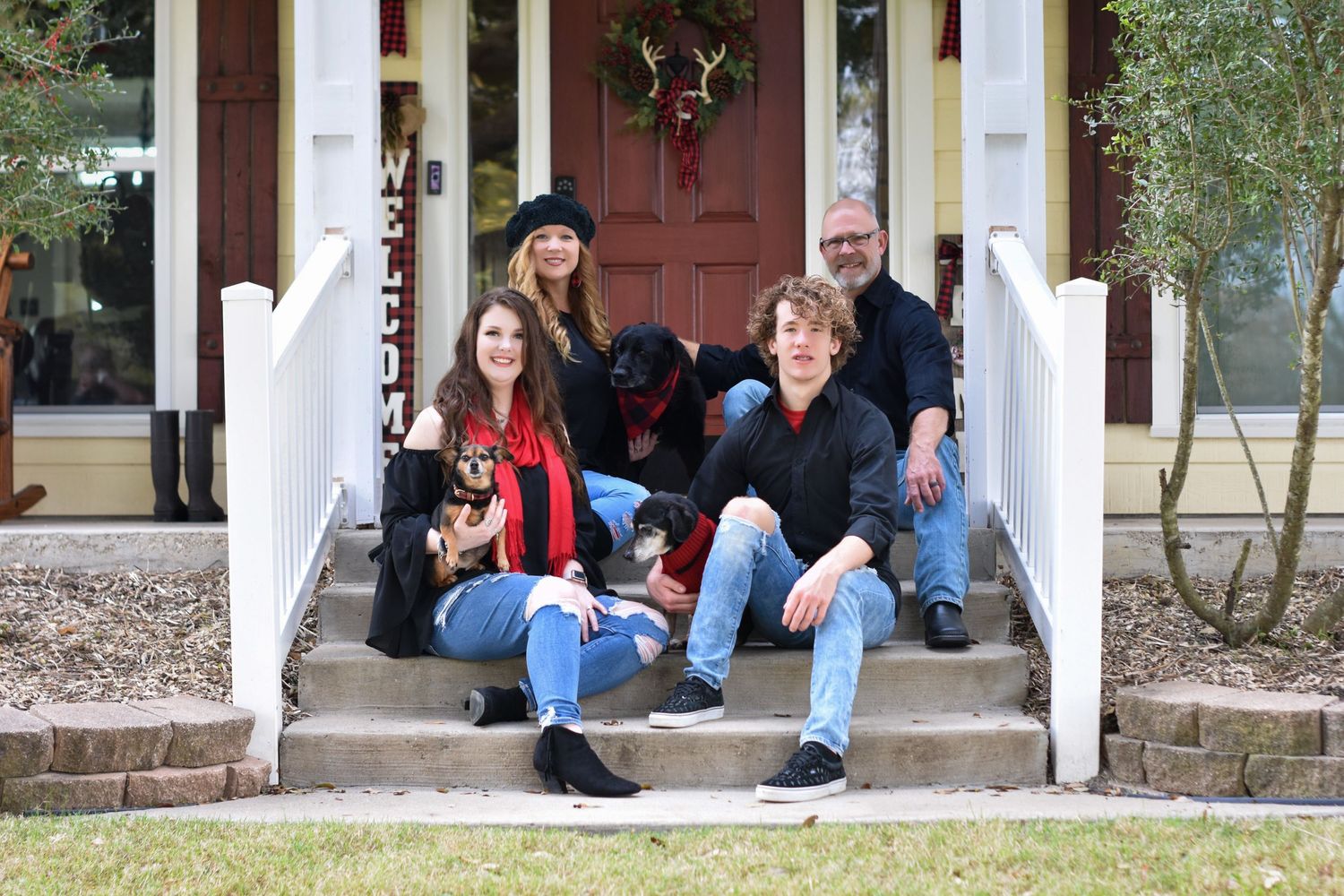Outdoor family portrait of a group sitting together on the front porch