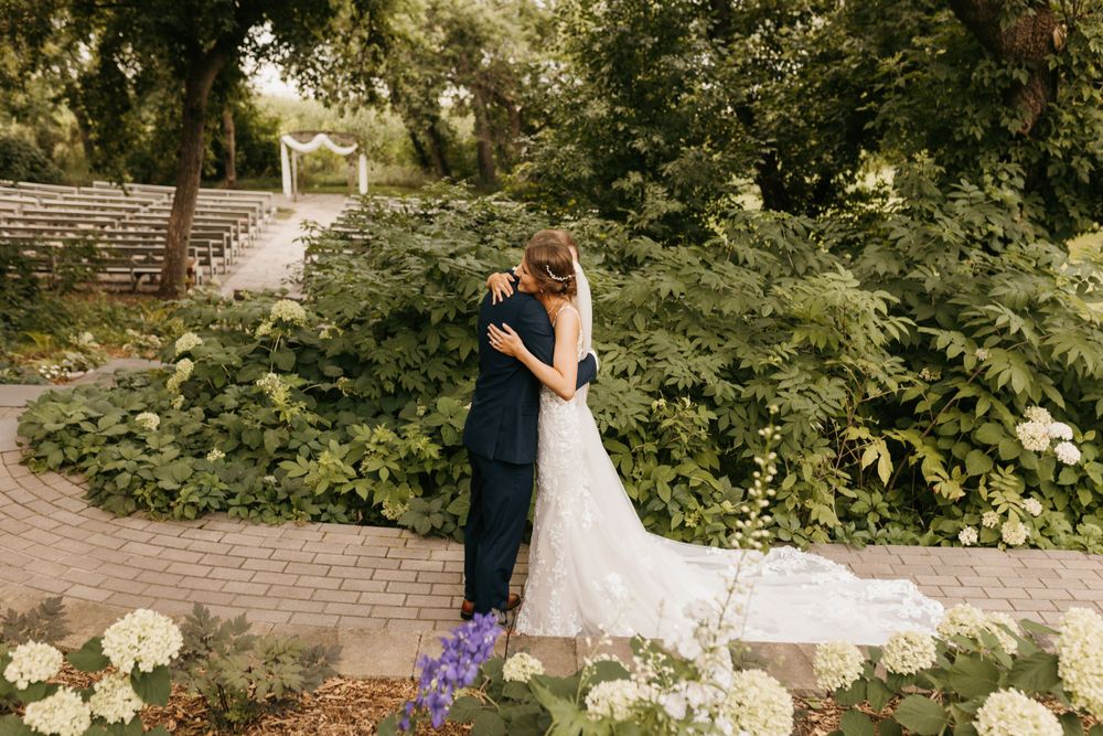 Bride and groom sharing romantic embrace in beautiful garden wedding venue.