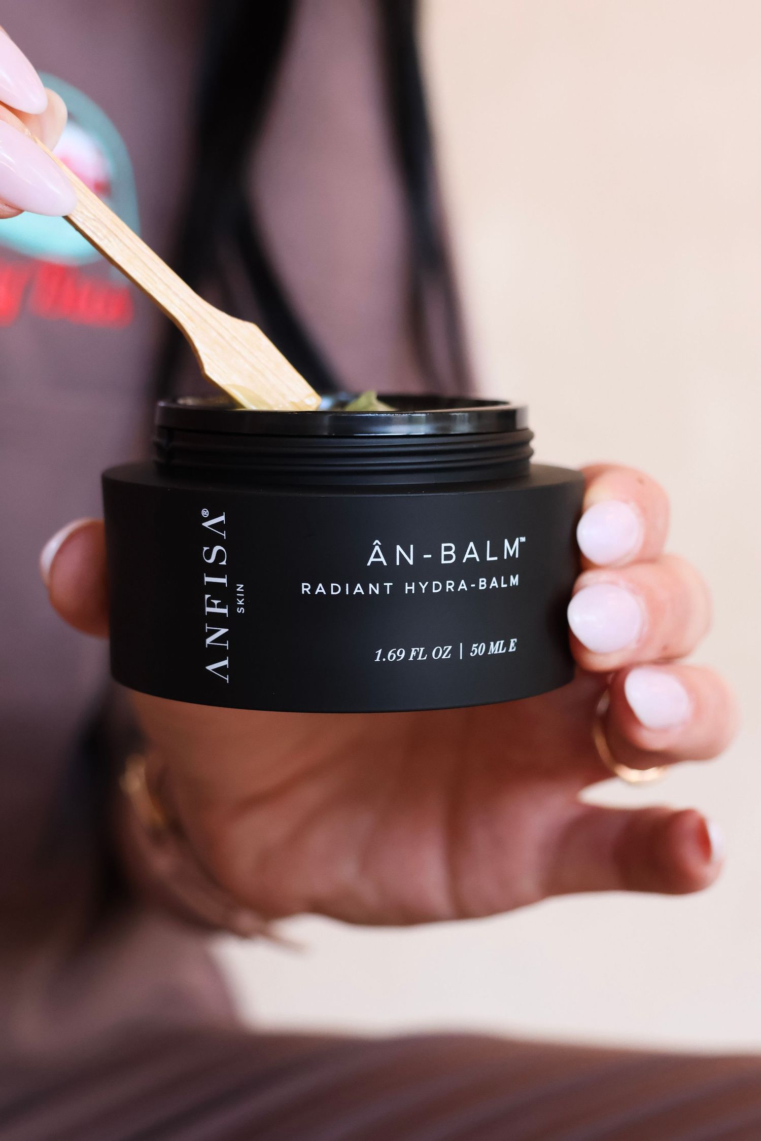Product shots of An-Balm skincare container showing black packaging details.