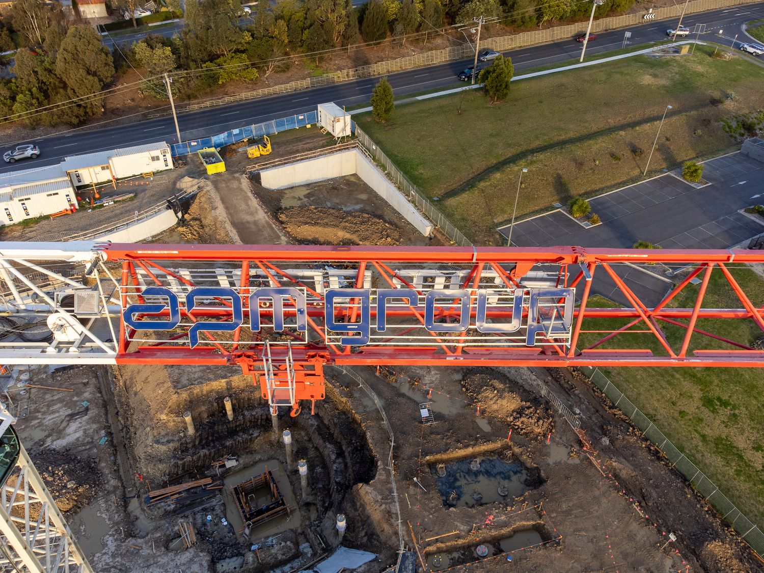 Aerial view of orange construction crane with graffiti text over active urban building site.