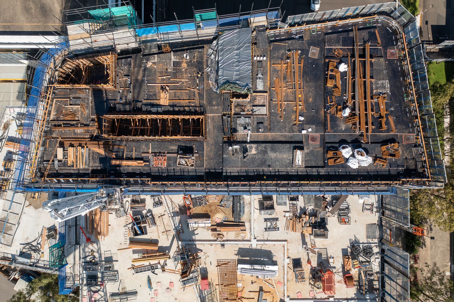 Aerial top-down view of a large excavated construction site with reinforced concrete formwork.