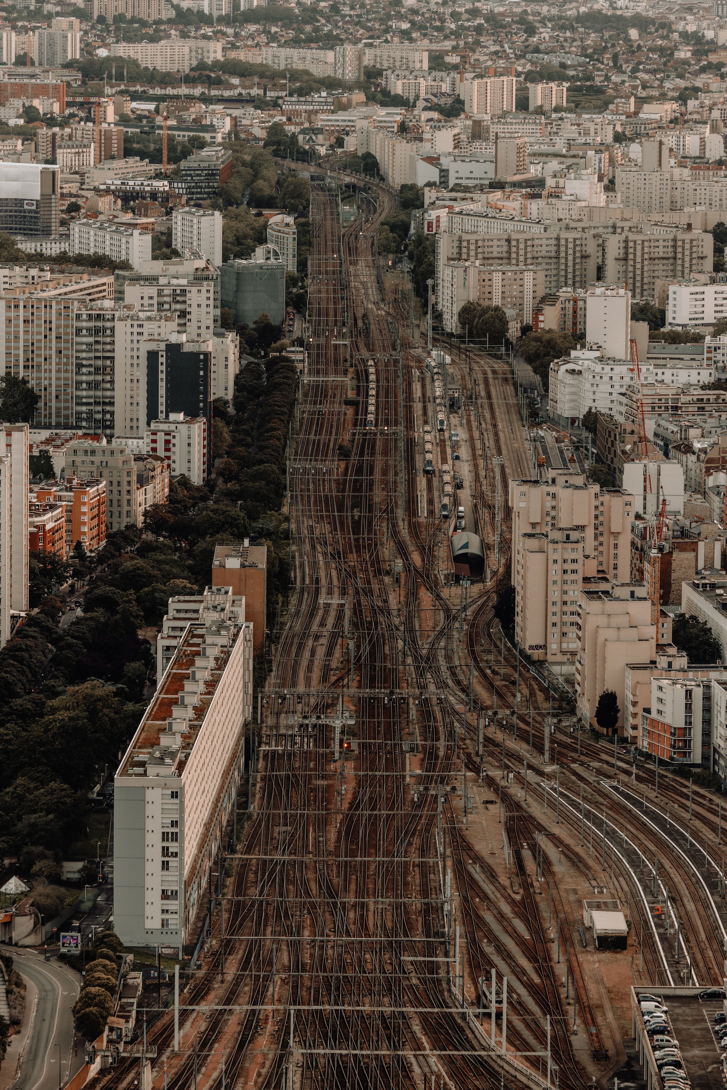 Aerial view of railway tracks cutting through dense urban architecture in Paris.