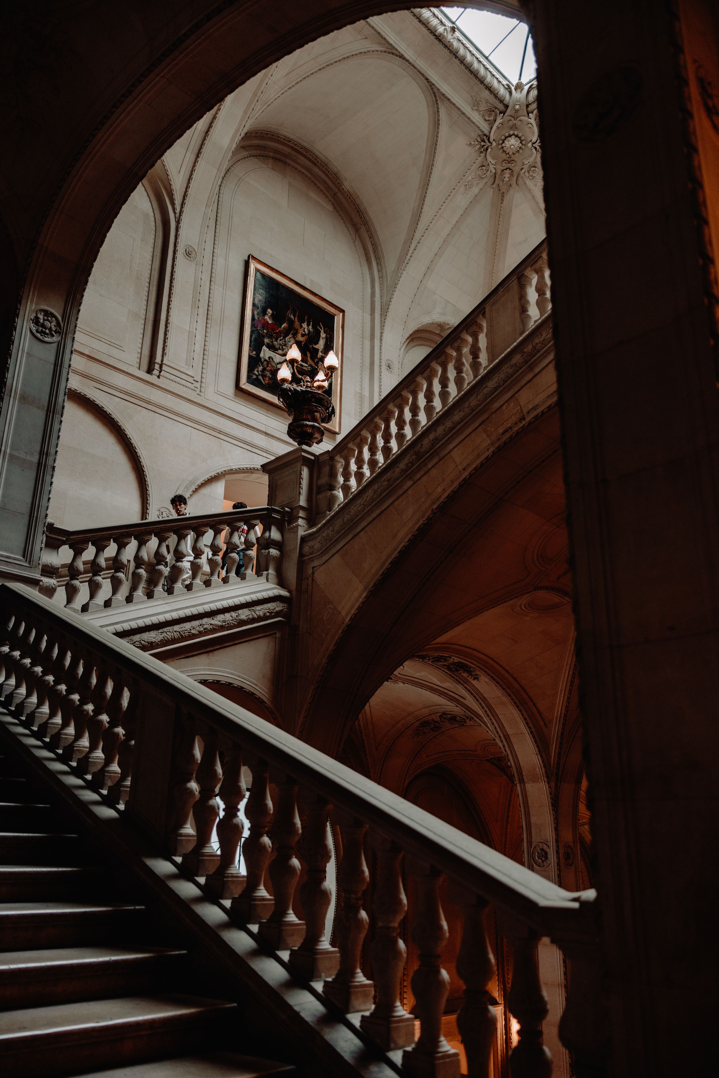 An elegant curved staircase with ornate balustrade in a historic building interior.