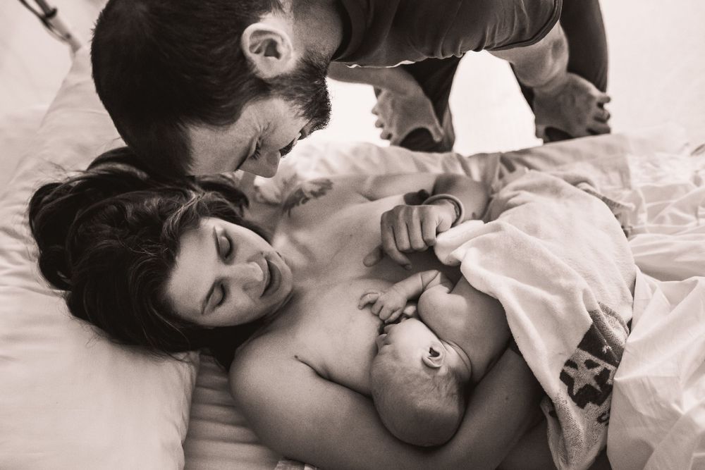 Intimate black and white sequence of parent and newborn bonding moments.