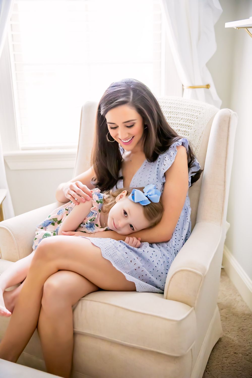 Tender moment between parent and child relaxing in cozy armchair.