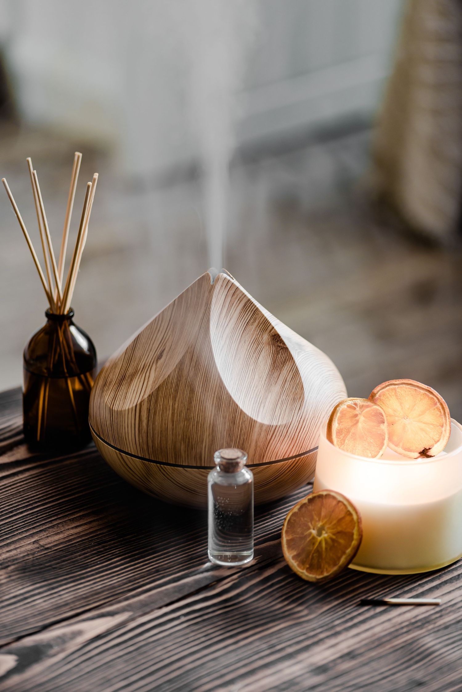 Close up of diffuser, essential oils and candles, rustic, natural, stylish, mindful, healthy living