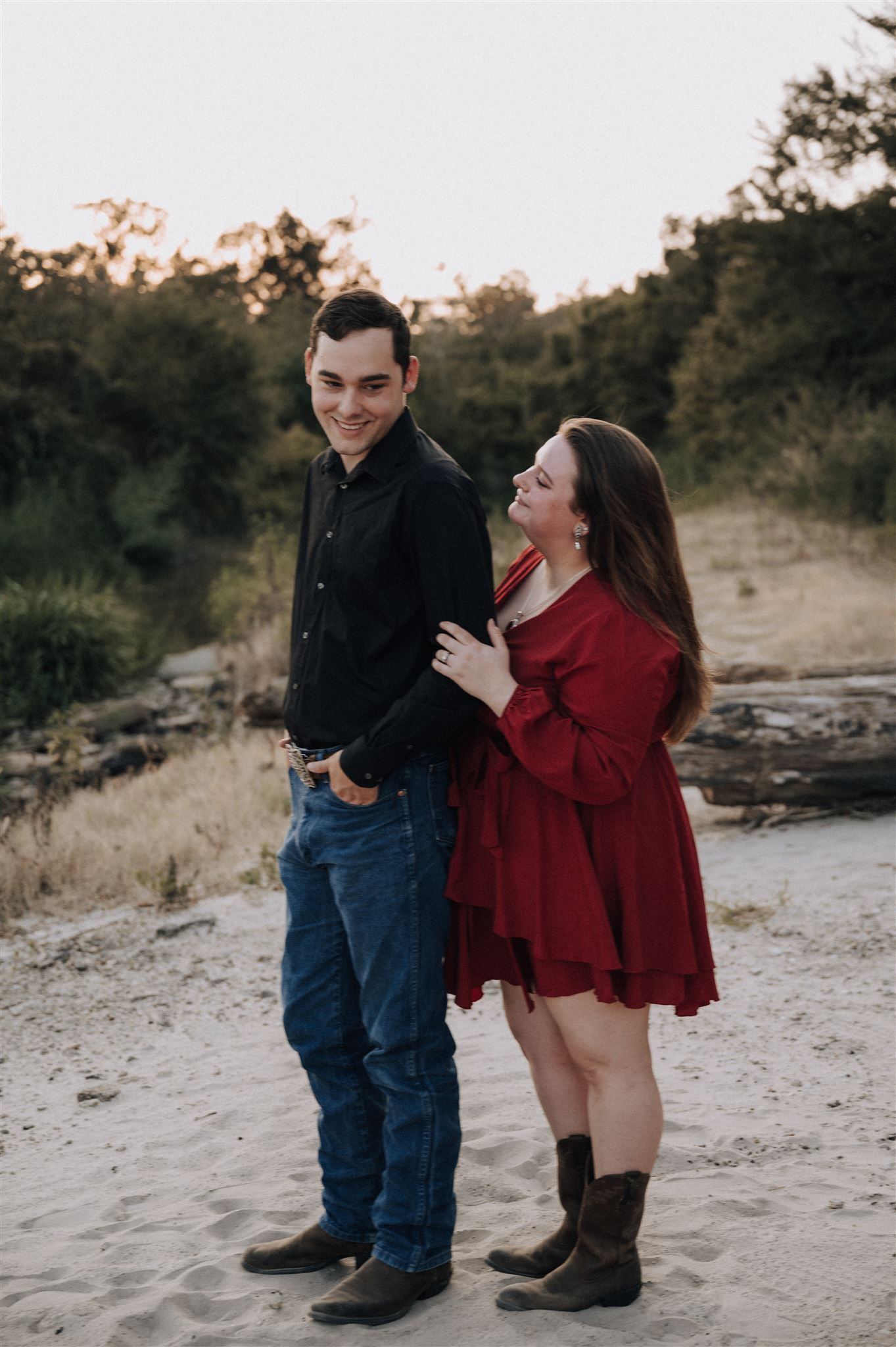 Happy couple poses together outdoors wearing red and black casual attire.