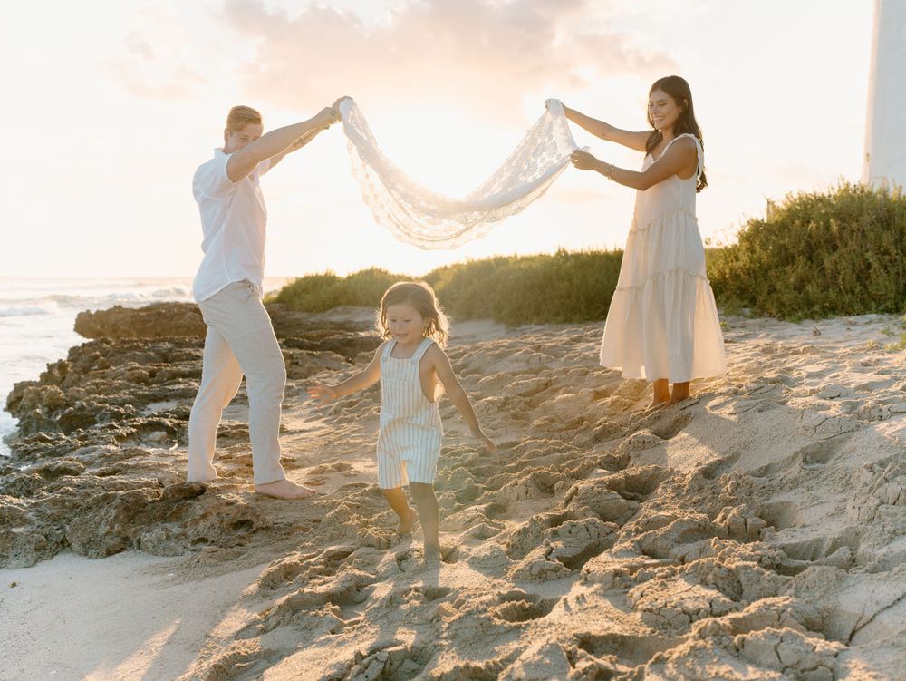 A family photoshoot by Moments With Kell on Oahu in Hawaii with family playing on the beach