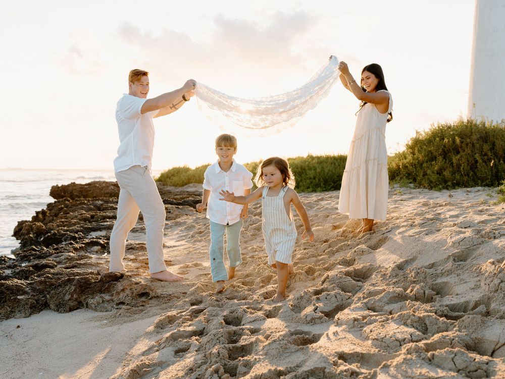 A family photoshoot by Moments With Kell on Oahu in Hawaii with family playing on the beach